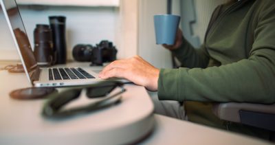 Caucasian Men in His 40s Remotely Working While Traveling in a Motorhome. Remote Computer Work From a Camper Van.